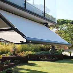 a large white awning over a lush green yard