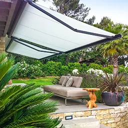a patio with a couch and a table under a awning