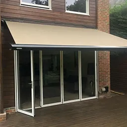 a patio covered with a white awning next to a brick building