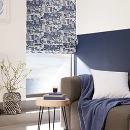 a living room with a couch and a window covered in a blue blanket
