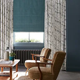 a living room filled with furniture and a window covered in curtains