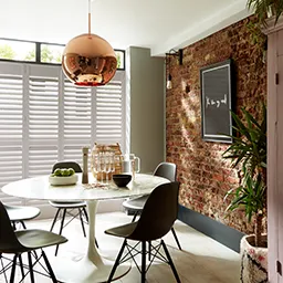 a dining room with a brick wall and a round table