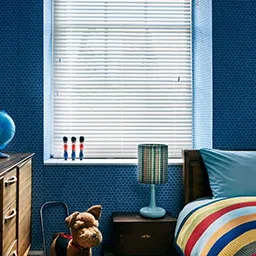a bedroom with blue walls and a striped bed spread
